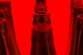 Ten green bottles in three rows shot with red light. Royalty Free Stock Photo