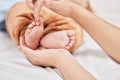 Ten perfect little toes. a young mother holding her sons feet while he sleeps. Royalty Free Stock Photo