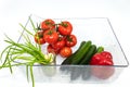 Ten red tomatoes on a branch, one red bell pepper, four large cucumbers, green onions in a glass Royalty Free Stock Photo