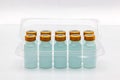 Ten vaccine bottles inside opened translucent plastic box