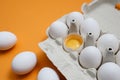 Ten white eggs in a carton package. Cardboard egg box on orange background Royalty Free Stock Photo