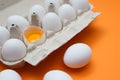 Ten white eggs in a carton package. Cardboard egg box on orange background Royalty Free Stock Photo