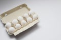 Ten white eggs in a carton package. Cardboard egg box on orange background Royalty Free Stock Photo