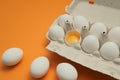 Ten white eggs in a carton package. Cardboard egg box on orange background Royalty Free Stock Photo