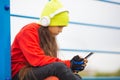 A ten-year-old girl on the street listening to music or sending messages to friends through smartphone applications. Royalty Free Stock Photo