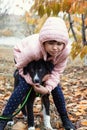 Ten year old girl walks in autumn park with a puppy