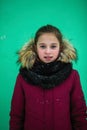 Ten-year-old girl in the winter near the green wall Royalty Free Stock Photo