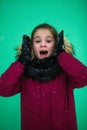 Ten-year-old girl in the winter near the green wall Royalty Free Stock Photo