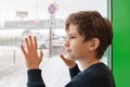 A ten years boy is looking out of a window Royalty Free Stock Photo