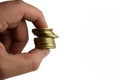 Ten yellow iron coins clamped with two fingers on a white background Royalty Free Stock Photo