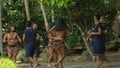 Group of young people dancing with typical costumes of the ethnic groups of the Ecuadorian Amazon in a park