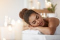 Tender african girl resting relaxing with closed eyes in spa salon.