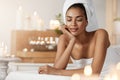 Tender african girl with towel on head resting relaxing in spa salon. Closed eyes. Royalty Free Stock Photo