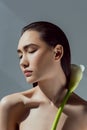 tender asian girl with closed eyes holding calla flower