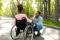 Tender black guy holding his disabled girlfriend's hand, expressing love and affection at city park