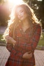 Tender blonde model in checkered dress posing in rays of sun at Royalty Free Stock Photo