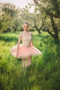 Tender dancer woman in green flowers landscape at sunset