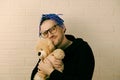 The Tender Embrace: A Man with Dreadlocks with Glasses Cherishing a Plush Toy