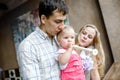 Tender family hugs. Mom, dad and daughter enjoy each other, girl playing a pipe Royalty Free Stock Photo