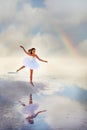 Tender girl ballerina in a white ballet dress in a graceful jump on the lake. Royalty Free Stock Photo