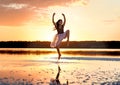 Tender girl young ballerina in pink transparent in a graceful jump on the lake