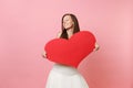 Tender happy bride woman with closed eyes in elegant white wedding dress holding empty blank red heart isolated on