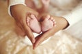 Tender interior photo of cute baby feet in mom hands