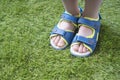 Tender kid legs in sandals close-up on the soft artificial grass Royalty Free Stock Photo