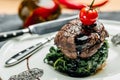 Tender lean medium rare beef fillet steak medallions with one sliced through to show the red meat with spinach, Restaurant menu, Royalty Free Stock Photo