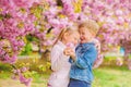 Tender love feelings. Little girl enjoy spring flowers. Giving all flowers to her. Surprising her. Kids enjoying pink Royalty Free Stock Photo