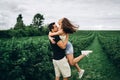 A tender loving couple walking in a field of currant. Man whirls woman in her arms. Love story Royalty Free Stock Photo