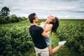 A tender loving couple walking in a field of currant. Man whirls woman in her arms. Love story Royalty Free Stock Photo
