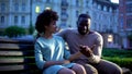 Tender male holding girlfriend hand on bench, romantic date in twilight city