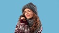 Tender millennial woman in warm fashionable clothes ready for winter season on blue studio background, panorama
