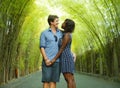 Tender mixed ethnicity couple cuddling outdoors with attractive black afro American woman and handsome Caucasian boyfriend or