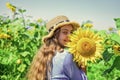 Tender moment. cheerful child in straw hat among yellow flowers. small girl in summer sunflower field. happy childrens Royalty Free Stock Photo