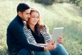 Embracing Couple in Love with Digital Tablet on Outdoor Date