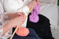 tender moment of two elderly women knitting with wooden needles and pink yarn, illustrating the age-old tradition of Royalty Free Stock Photo