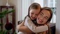 Tender mother daughter hug New Year tree place portrait. Cute family embracing Royalty Free Stock Photo