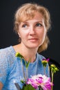 Tender pensive woman 45 years old with flowers Royalty Free Stock Photo