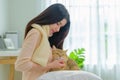 A tender portrait of a beautiful young Asian woman, comfortably seated on her bed, holding her cute cat tightly. This intimate Royalty Free Stock Photo