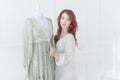 Tender portrait of a young dreamy redhead woman in nightdress. She is standing in dress room and planning to wear beautiful vintag Royalty Free Stock Photo