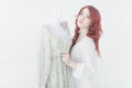 Tender portrait of a young dreamy redhead woman in nightdress. She is standing in dress room and planning to wear beautiful vintag Royalty Free Stock Photo