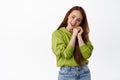 Tender redhead woman gazing and admire something, smiling romantic and adorable, standing in casual clothes against