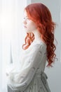 Tender retro portrait of a young beautiful dreamy redhead woman.