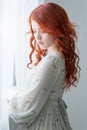 Tender retro portrait of a young beautiful dreamy redhead woman. Royalty Free Stock Photo