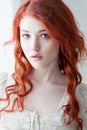 Tender retro portrait of a young beautiful dreamy redhead woman.