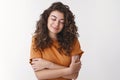 Tender romantic gorgeous armenian young curly-haired woman wearing orange t-shirt close eyes smiling sensually recall