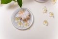 Tender sand tart with powdered sugar on plate with some jasmine flowers around on white table. Sweet pastry, spring blossom