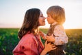 Tender scene of loving son with mom on sunset backdrop. Beautiful family. Cute 3 year old kid with mother. Parenthood